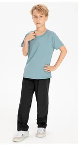 Full view of boy wearing black quick-dry loose sports pants on white background.