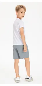 Detailed back view of child boy in grey quick-dry sports shorts and white mesh tee
