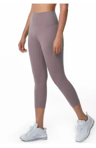 Detailed side view of high-waisted mauve yoga capri pants with tight fit sports design.