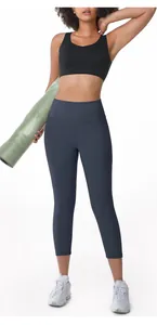 Professional model wearing high-waisted navy capri yoga pants and black sports bra