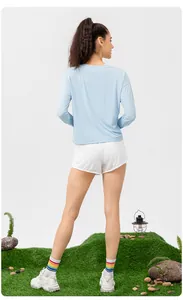 Vue arrière détaillée d'une femme avec un haut de protection solaire bleu et un short blanc.