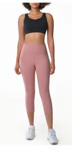Close-up view of women's high-waisted 3/4 length pink yoga leggings for fitness and running