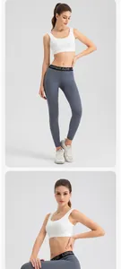 Detailed view of high-waisted grey yoga leggings and white sports bra on a female model
