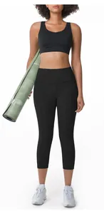 Full view of women's black high-waisted yoga pants and sports bra with a yoga mat.