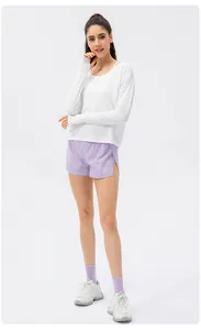 Vue complète d'une femme en t-shirt de protection solaire blanc et short violet.