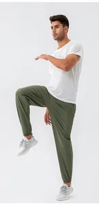 Sneldrogende olijfgroene nylon herenjoggingbroek getoond in actie voor fitnesstraining