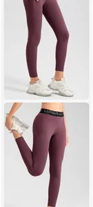 Detail of plum high-waisted yoga leggings with side pockets and UPGRADE waistband text