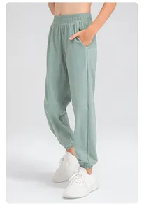 Vue détaillée montrant la texture du pantalon de jogging en nylon pour garçon, vert clair