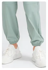 Gros plan sur un pantalon de jogging vert menthe à séchage rapide et baskets blanches