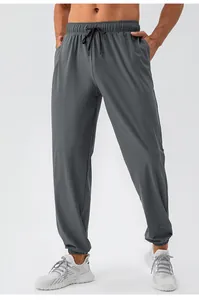 Detailweergave van de grijze, sneldrogende sportbroek voor heren met elastisch trekkoord.