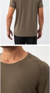 Dettaglio del tessuto mesh traspirante e scollo su t-shirt sportiva da uomo verde oliva