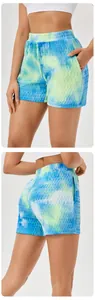 Front and back detail view of blue tie-dye textured athletic shorts for women in studio.