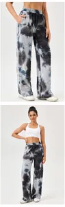 Detail van wijde sportbroek voor dames met tie-dye print, honingraattextuur en hoge taille.