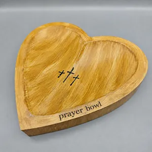 Detailed view of a hand-carved heart-shaped solid wood prayer bowl with cross engravings
