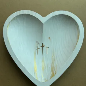 Detailed top view of a white heart-shaped wooden prayer bowl with gold accents