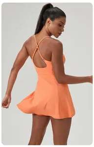 Detailed back view of orange fitness tennis dress featuring elegant cross strap design