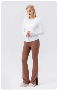Vue en pied d'une femme portant un haut de protection solaire blanc et un pantalon de yoga brun