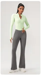 Modell trägt hellgrüne Yoga-Jacke mit Reißverschluss und graue Schlaghose für Fitness