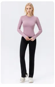 Full body view of a woman wearing a purple long sleeve yoga shirt and black pants