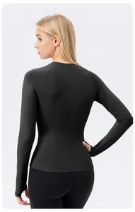 Professional back view of women's black long sleeve yoga top featuring functional thumb holes