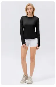 Femme portant un haut de protection solaire noir à manches longues pour le yoga.
