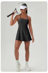 Professional athletic woman in black tennis dress holding a racket in a studio setting