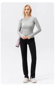 Caucasian model wearing grey long sleeve sun protection yoga top and black flare leggings