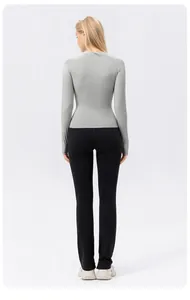 Back view of women's tight long-sleeve yoga top and black sports pants for gym fitness