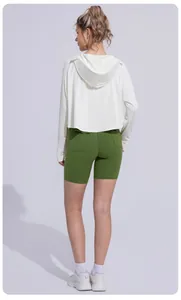 Back view of a white hooded sun protection jacket paired with green biker shorts.