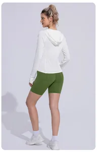 Back view of woman in white slim-fit UV sun protection jacket and green biker shorts