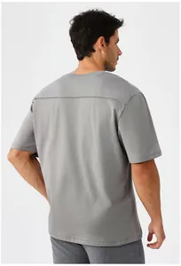 Πίσω όψη ανδρικού γκρι αθλητικού T-shirt γρήγορου στεγνώματος με οριζόντια ραφή στην πλάτη.