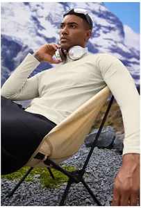 Model wearing men's half-zip thermal sports top in a scenic mountain outdoor setting