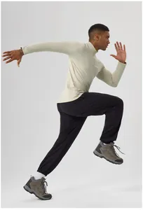 Detailed side view of man in warm half-zip long sleeve running shirt and black pants