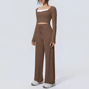 Brown two-piece yoga set with long-sleeve crop top and wide-leg trousers detail