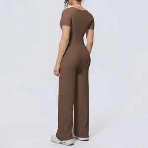 Back-side view of a woman wearing a brown short-sleeve yoga top and wide-leg pants set