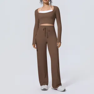 Model wearing a three-piece brown yoga set with long-sleeve top and wide-leg pants