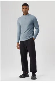 Men's athletic outfit styling featuring a grey-blue half-zip top and black joggers