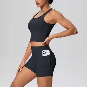 Detail van zwarte yoga-set met korte broek met zijzak en sportbeha voor fitness dames