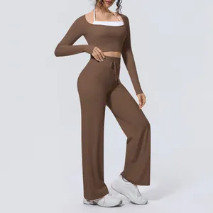 Brown brushed long-sleeve crop top and wide-leg yoga pants set with white sports bra detail.