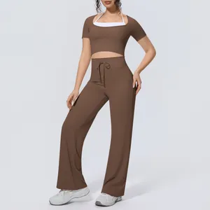 Two-piece yoga set featuring brown short-sleeve crop top and wide-leg pants on model
