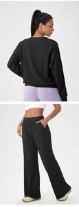 Detail view of black waffle knit lounge set with loose sweatshirt and wide leg pants.