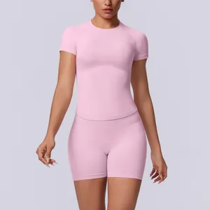Detailweergave van een roze naadloze yogaset met strakke top en korte broek met hoge taille