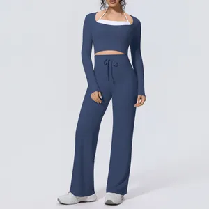 Close-up of navy blue two-piece yoga set with long sleeve crop top and wide leg pants
