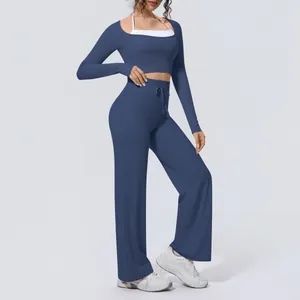 Detailed view of women's slate blue long sleeve yoga set with wide leg trousers.