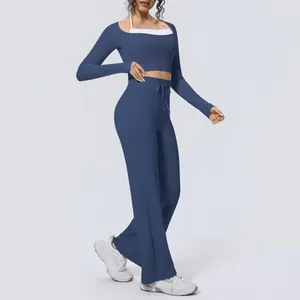 Full view of navy blue two-piece yoga set with long sleeve crop top and wide leg pants