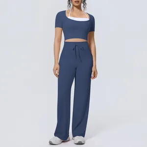 Full view of women's blue two-piece sports yoga set with halter top and wide-leg pants