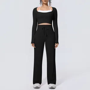 Professional black yoga set featuring a long sleeve crop top and matching wide leg trousers