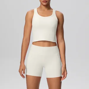 Detail van witte tweedelige yogaset met gewatteerde sportbeha en korte broek met zakken.