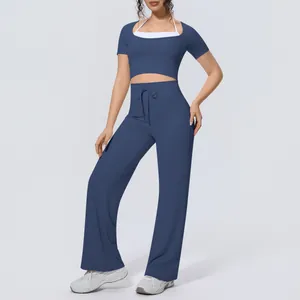 Two-piece navy blue yoga set with halter crop top and wide-leg pants.