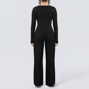 Back view of black long-sleeve yoga set with slim fit top and wide-leg trousers.